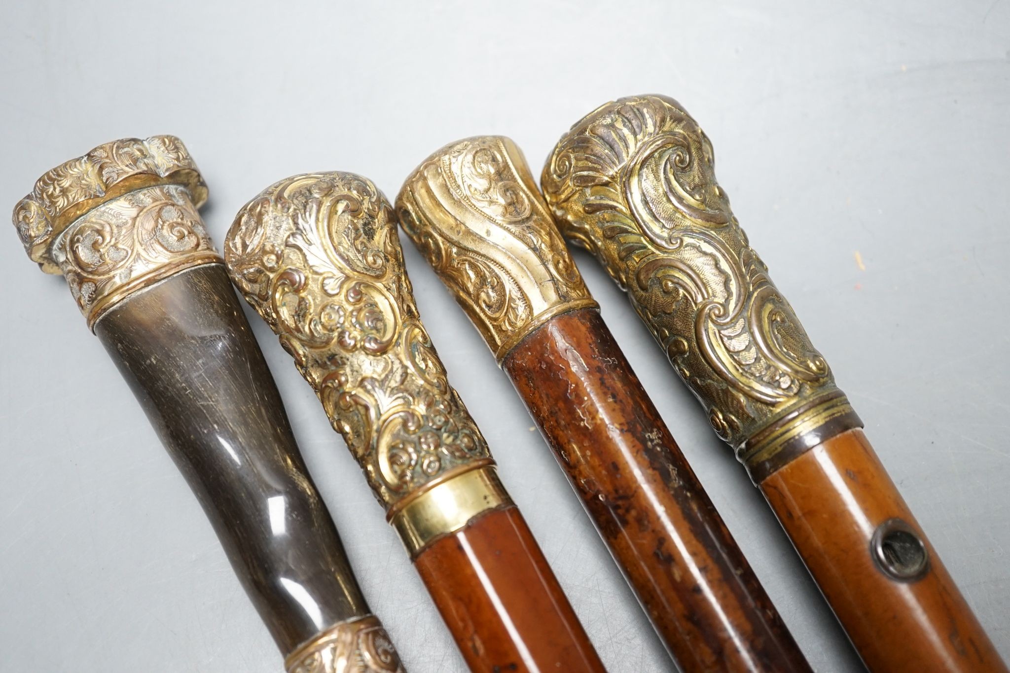 Four Victorian gilt-metal mounted walking canes, longest 97cm